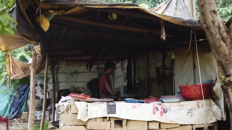 man cooking at a makeshift food stall in rural india