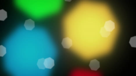 animation of spots falling over multi coloured spots on black background