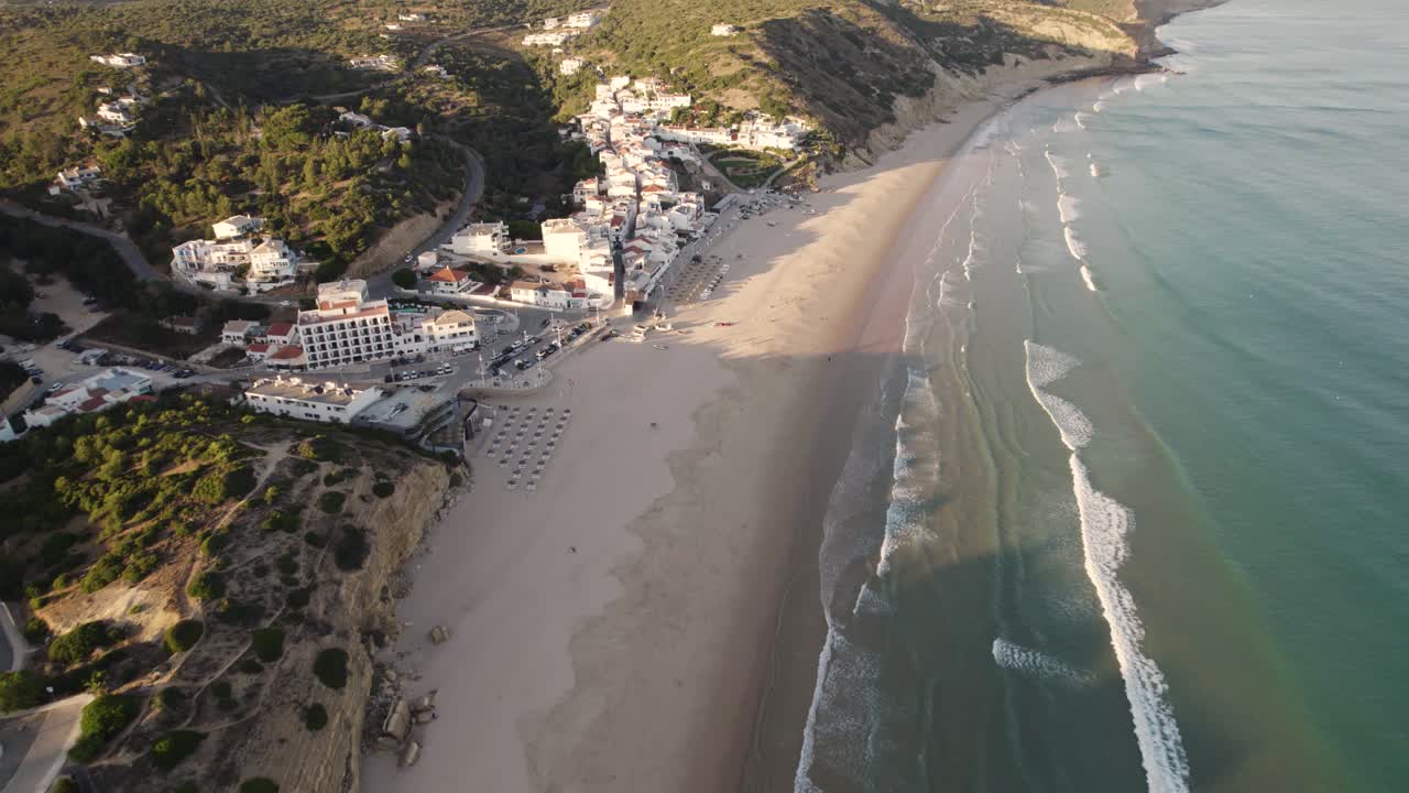 olas lavando en la playa de arena vacía, salema, algarve