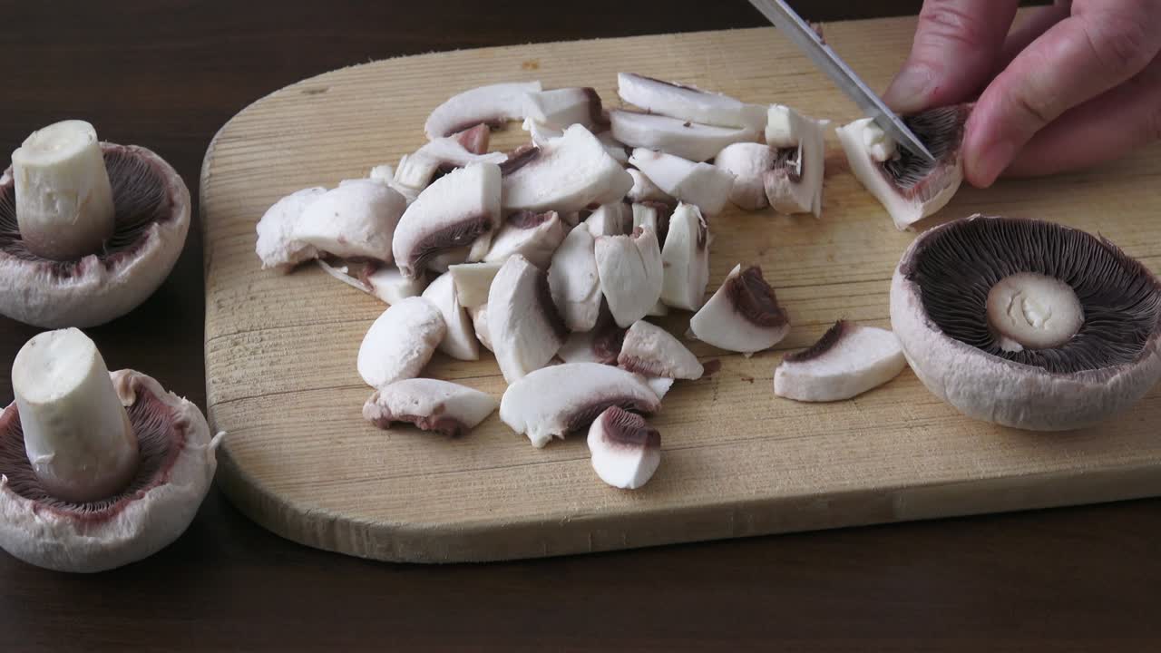 mujer con un cuchillo de cocina, cortando setas descascaradas y blancas
