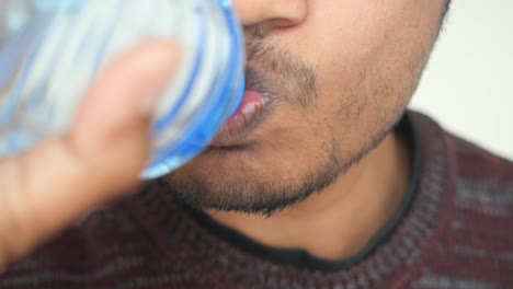 close-up of a person drinking water from a bottle