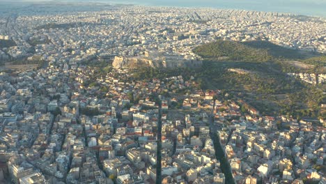 flying high wide panorama of athens city towards iconic acropolis temple, greece