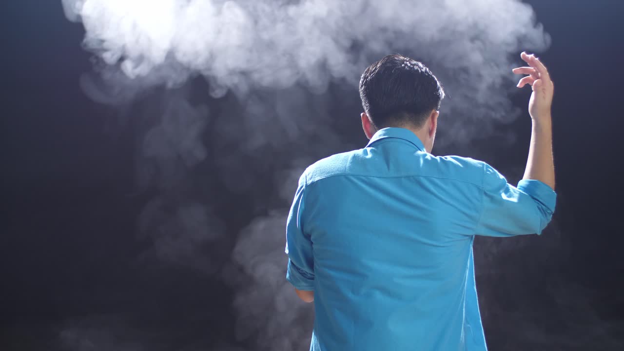 연기 배경으로 파란 셔츠를 입은 남자