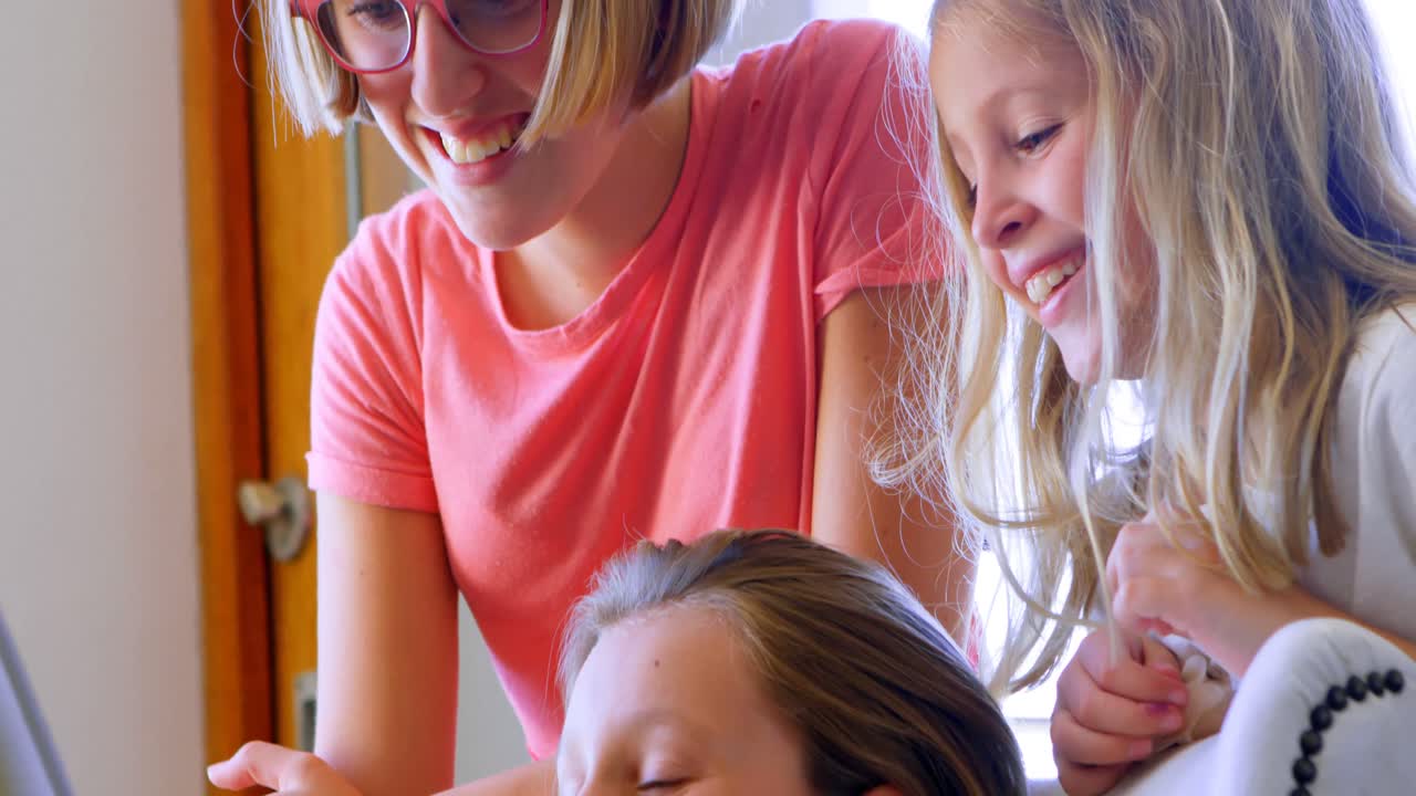 Siblings using digital tablet in living room 4k