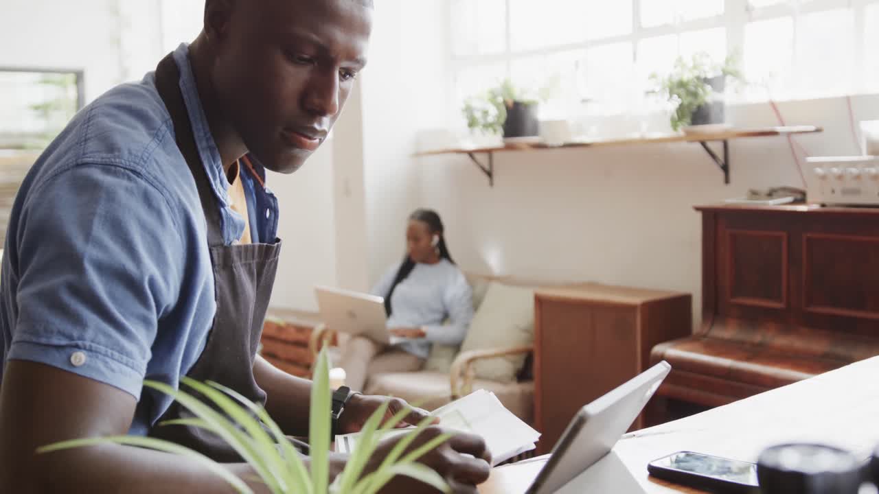 propietario de una cafetería afroamericano usando una tableta y haciendo papeleo, cámara lenta