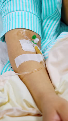 female hand with connected wire from drop counter. patient having infusion in hospital ward. close up. vertical video