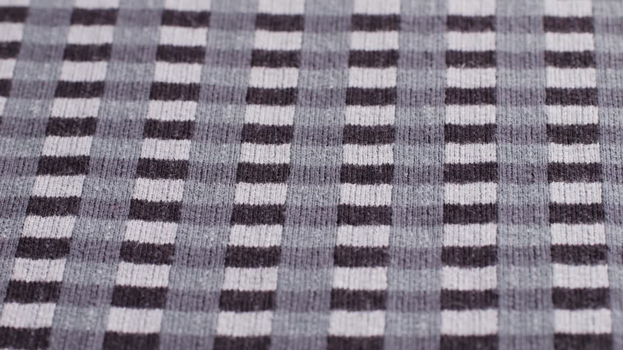 Checkered print textile cloth texture close-up macro. Black and white clothes.Fashion fabric multicolor.High quality 4k footage