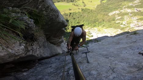 active and extreme tourism experience filmed by a young and fit man, climbing up between two cliffs high up on a mountain side