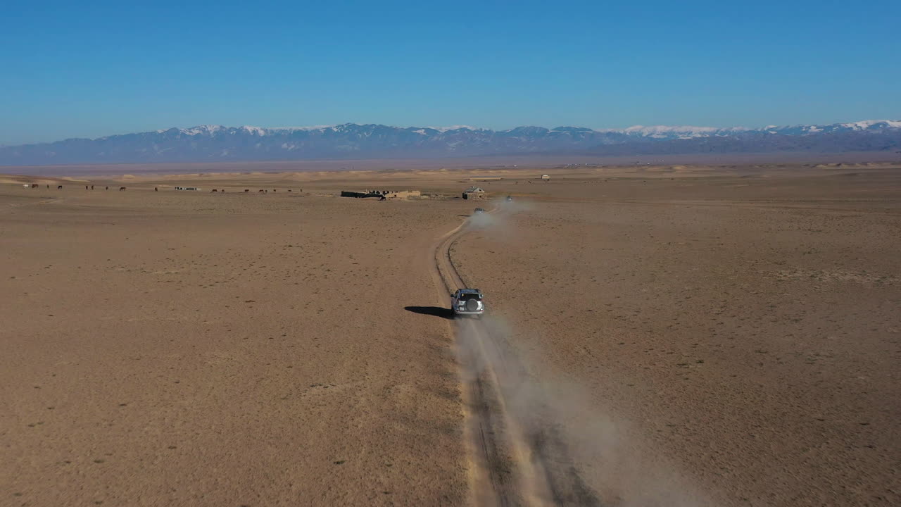 카자흐스탄 차린 협곡을 여행하는 자동차 캐러밴의 공중 추적 드론 샷