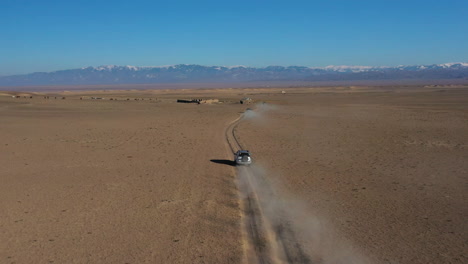 toma aérea de drones de seguimiento de una caravana de automóviles que viaja en el cañón charyn, kazajstán