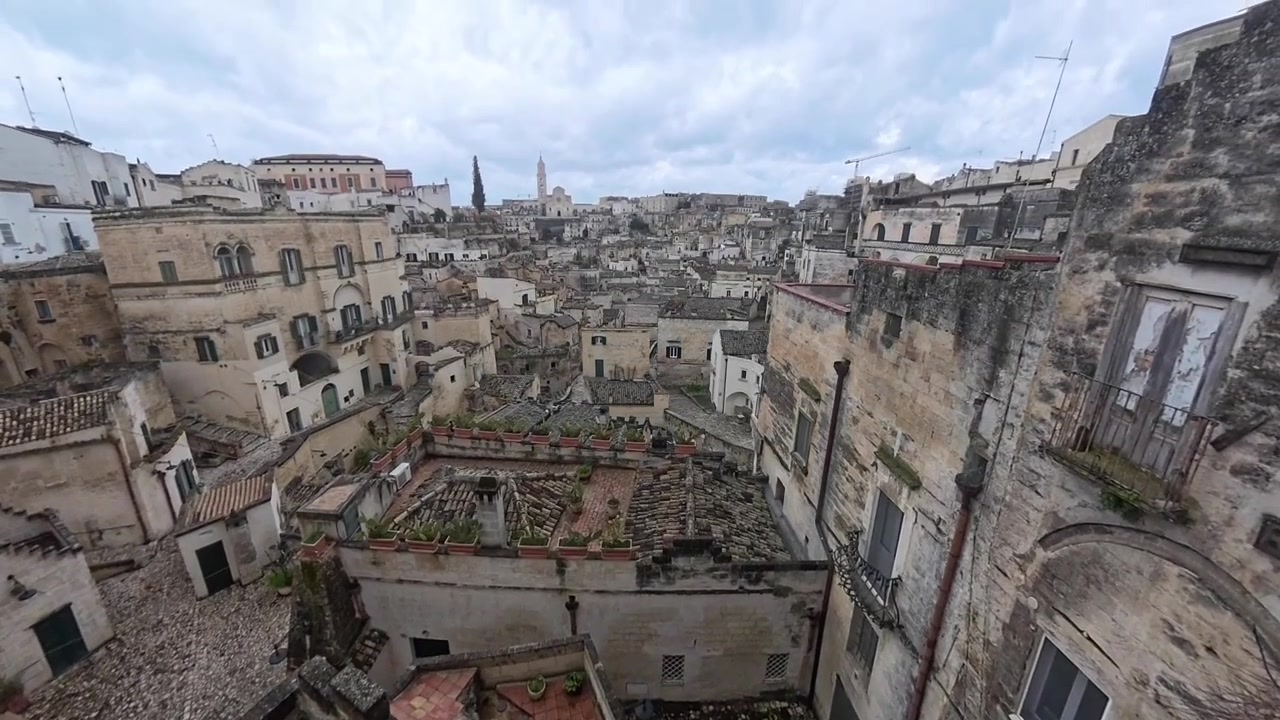 Panoramica verticale che rivela un'ampia inquadratura dell'antica città di Matera.