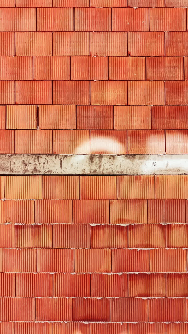 Terracotta tiles create an interesting pattern of shadows on a wall in a bright setting during daylight hours in a warm location