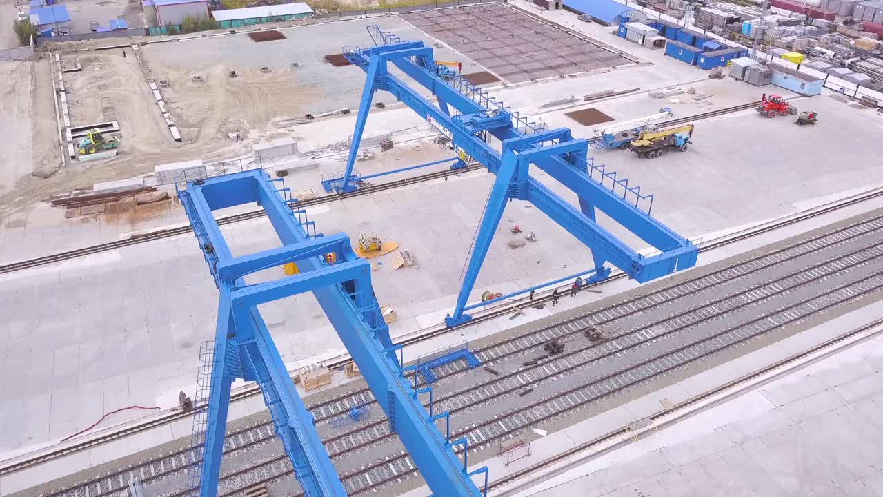 vista aérea del sitio de construcción con grúas de pórtico azules