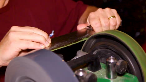 man professionally sharpening a knife