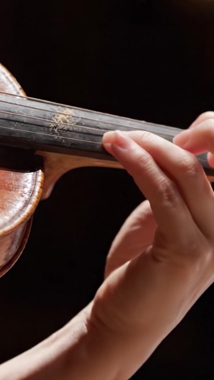 Una Selezione di Movimenti Espressivi delle Mani su un Violino: Catturando il Gesto Artistico di una Performance d'Archi Attraverso Due Inquadrature Distinte