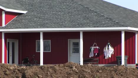 a red house has two small clotheslines with laundry hanging out to dry