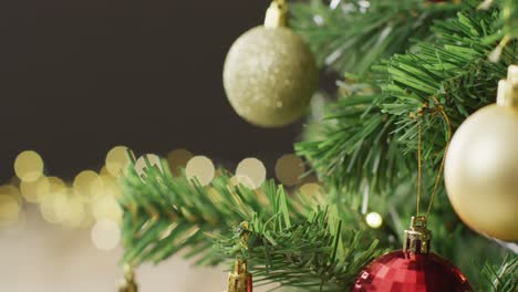 video of christmas tree with baubles and fairy lights on black background