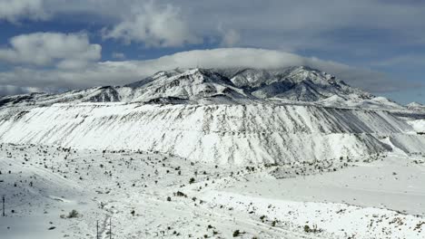 Vista-Aérea-A-Través-De-Las-Laderas-De-La-Cumbre-De-La-Montaña-Blanca-Cubierta-De-Nieve-A-Gran-Altitud