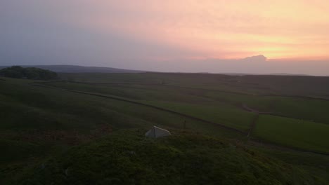a tranquil, serene place on the top of the hill, where a solo traveller put his tent and will take an overnight stand in errwood reserve at sunset