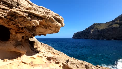 Waves-hitting-the-rocky-coast-of-Majorca,-sunny-day,-in-Balearic-islands,-Spain