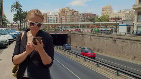 woman using her phone on a busy city street