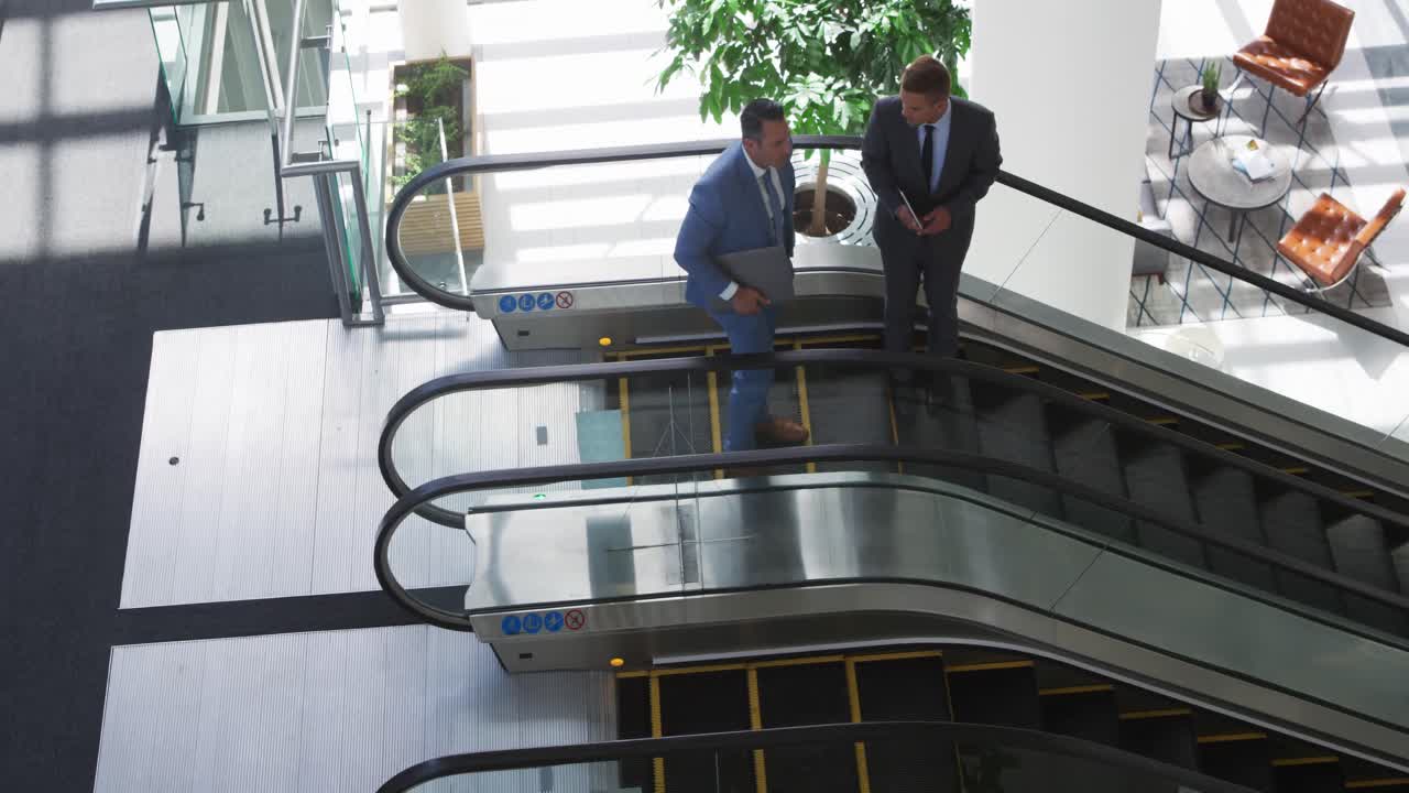 Empresários em uma escada rolante em um prédio moderno
