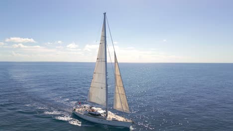 Aerial-tracking-shot-of-New-Florida-Sailing-Yacht-Boat-cruising-on-Ocean-in-sunlight