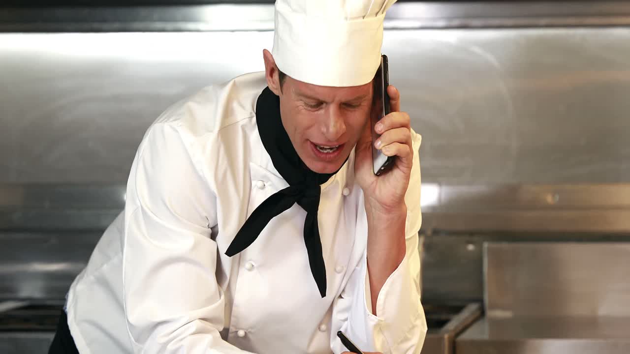 el jefe de cocina sonriente hace una llamada