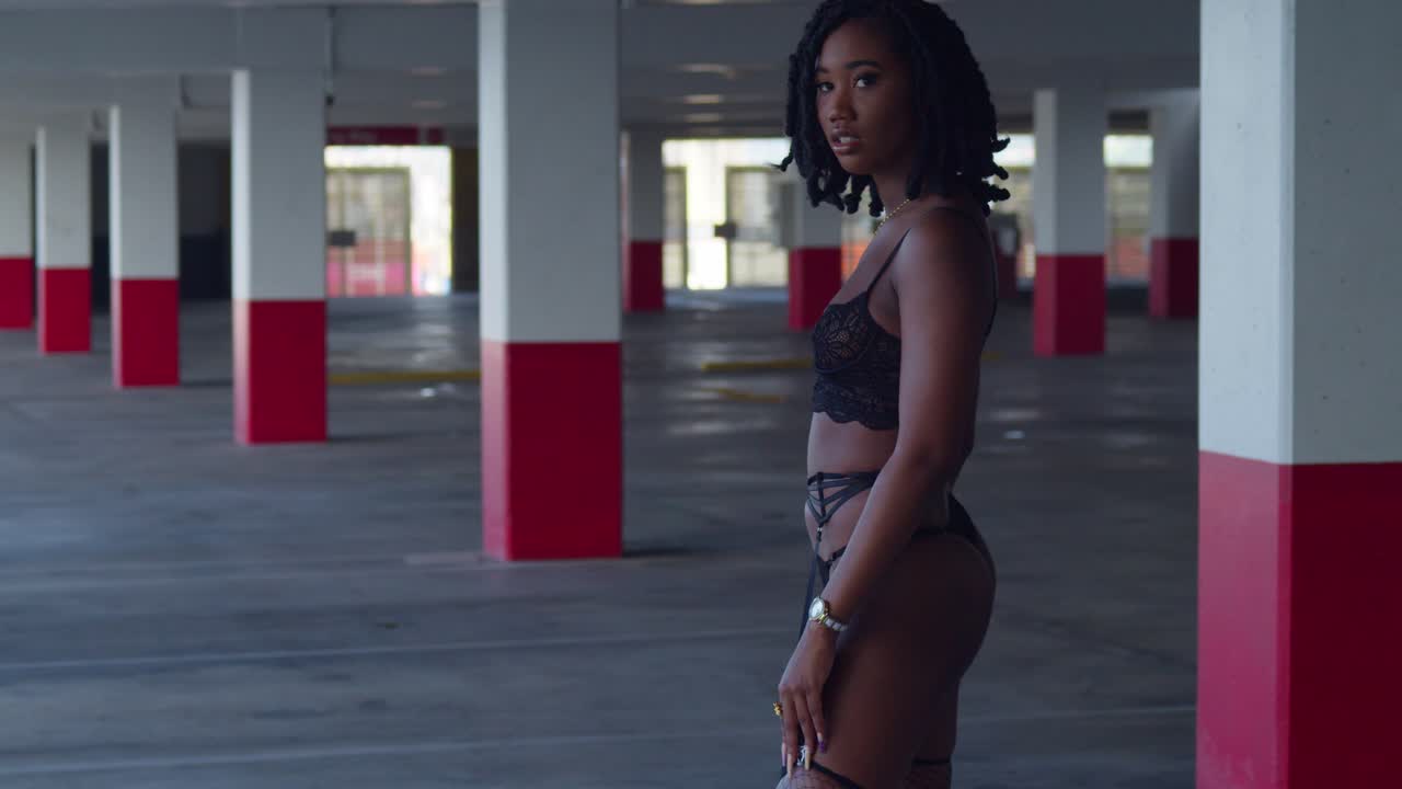 Premium stock video - Sexy girl in black lingerie walking in a parking  garage in the city on a sunny day