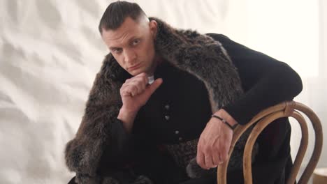 portrait of a handsome, charming young man in embroidered authentic ukrainian attire with a fur coat, posing in front of the camera