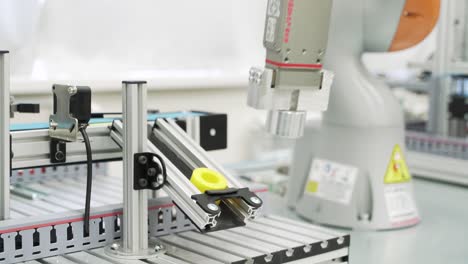 componentes de manipulación de brazos de robots industriales en una cinta transportadora