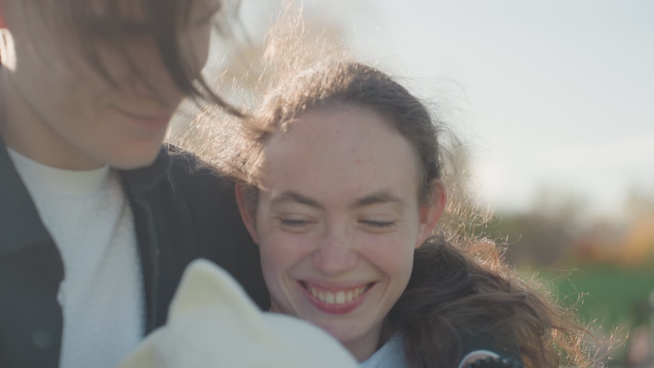 Familieglede fanget. Smilende foreldre tilbringer kjærlig tid med barnet sitt ute om høsten. Glade familieøyeblikk fanget mens foreldre og barn nyter solskinn og fargerike blader ute.