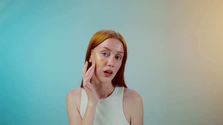 Donna che applica maschera viso dorata