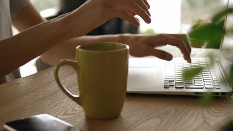 man having coffee while using laptop at home 4k