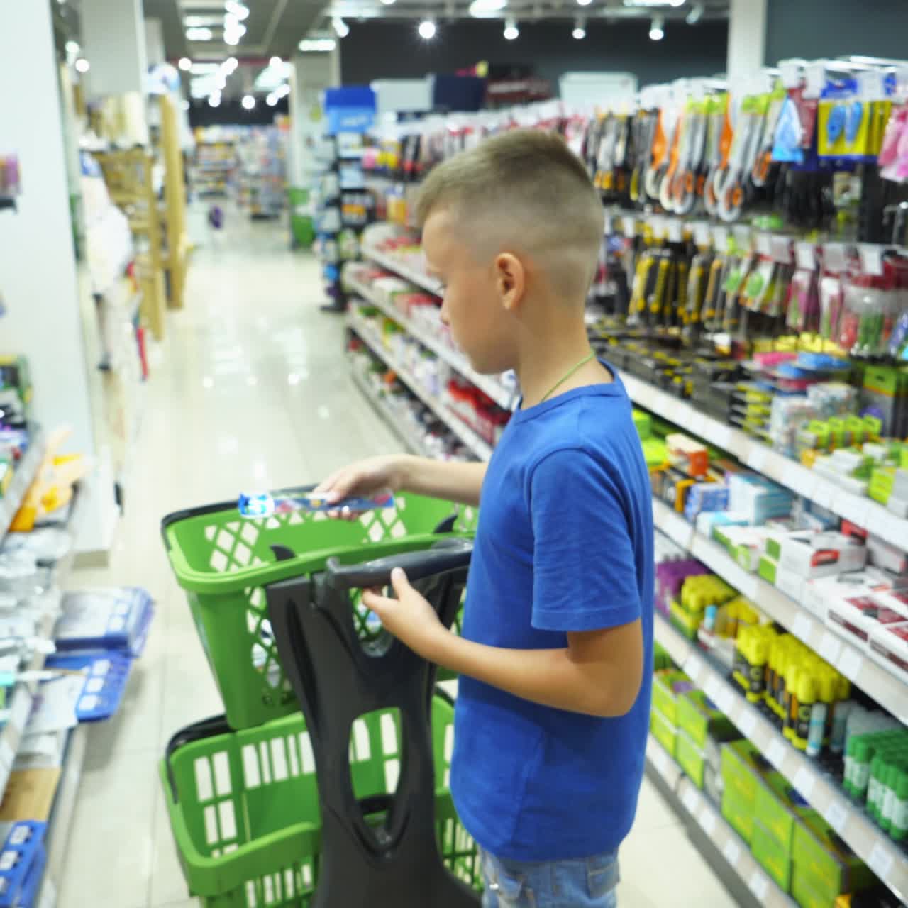 VINNITSA, UKRAINE - AUGUST 20, 2018: Boy choosing buying stationery in store preparing for first day in school. Back to school concept.
