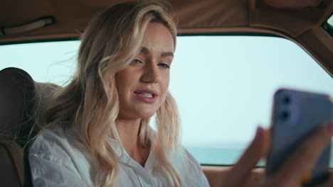 blonde talking video call telephone in automobile close up. woman videocalling