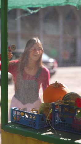 woman washing pumpkins at a farmers market