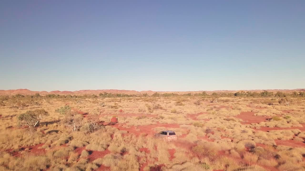 공중 드론은 호주 사막에서 자갈길을 따라 4wd 트럭을 따라갑니다.