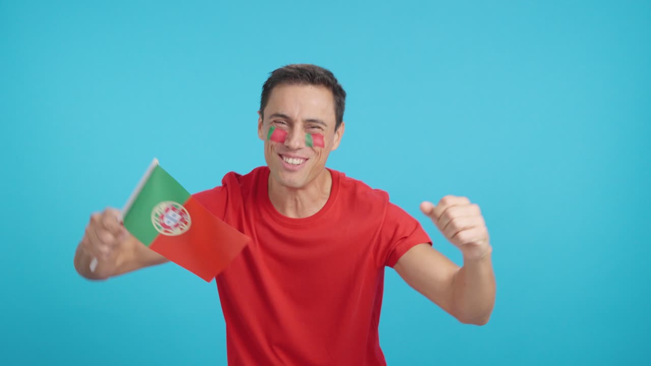 Man cheering for Portugal screaming and waving a national flag