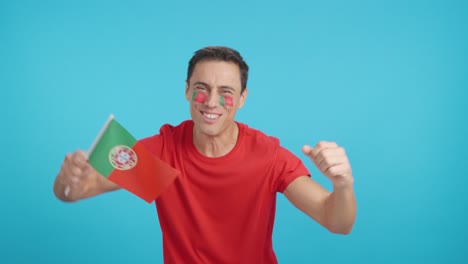 Man cheering for Portugal screaming and waving a national flag