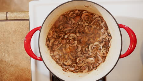 overhead view of mushrooms sautéing in a pot on the stove - dutch oven cooking mushrooms