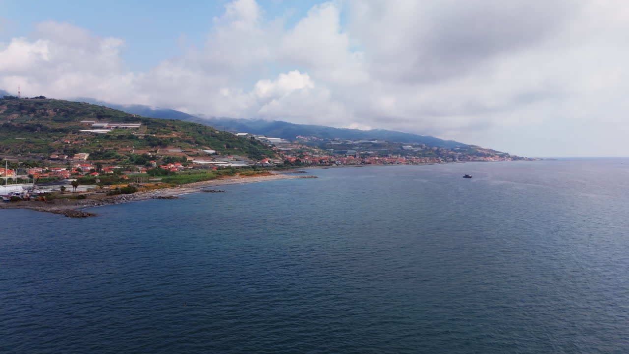 Clear coastal view of Liguria, Italy, with hills and village near the Mediterranean Sea