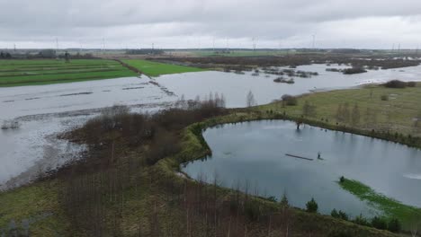 Vista-Aérea-De-La-Crecida-Del-Agua-En-Primavera,-Inundación-Del-Río-Alande,-Agua-Marrón-Y-Fangosa,-Campos-Agrícolas-Bajo-El-Agua,-Día-Nublado,-Amplio-Disparo-De-Drones-Avanzando