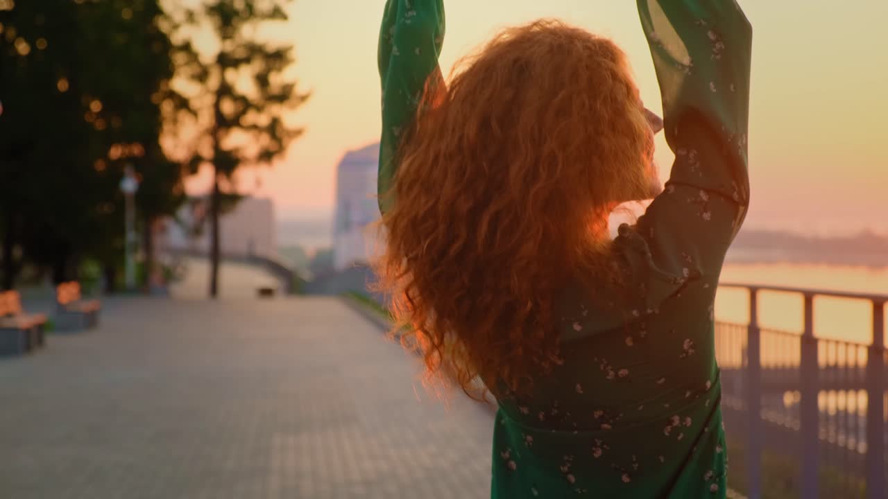 una mujer disfrutando del atardecer junto al río.