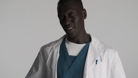 tired african american doctor on grey background.