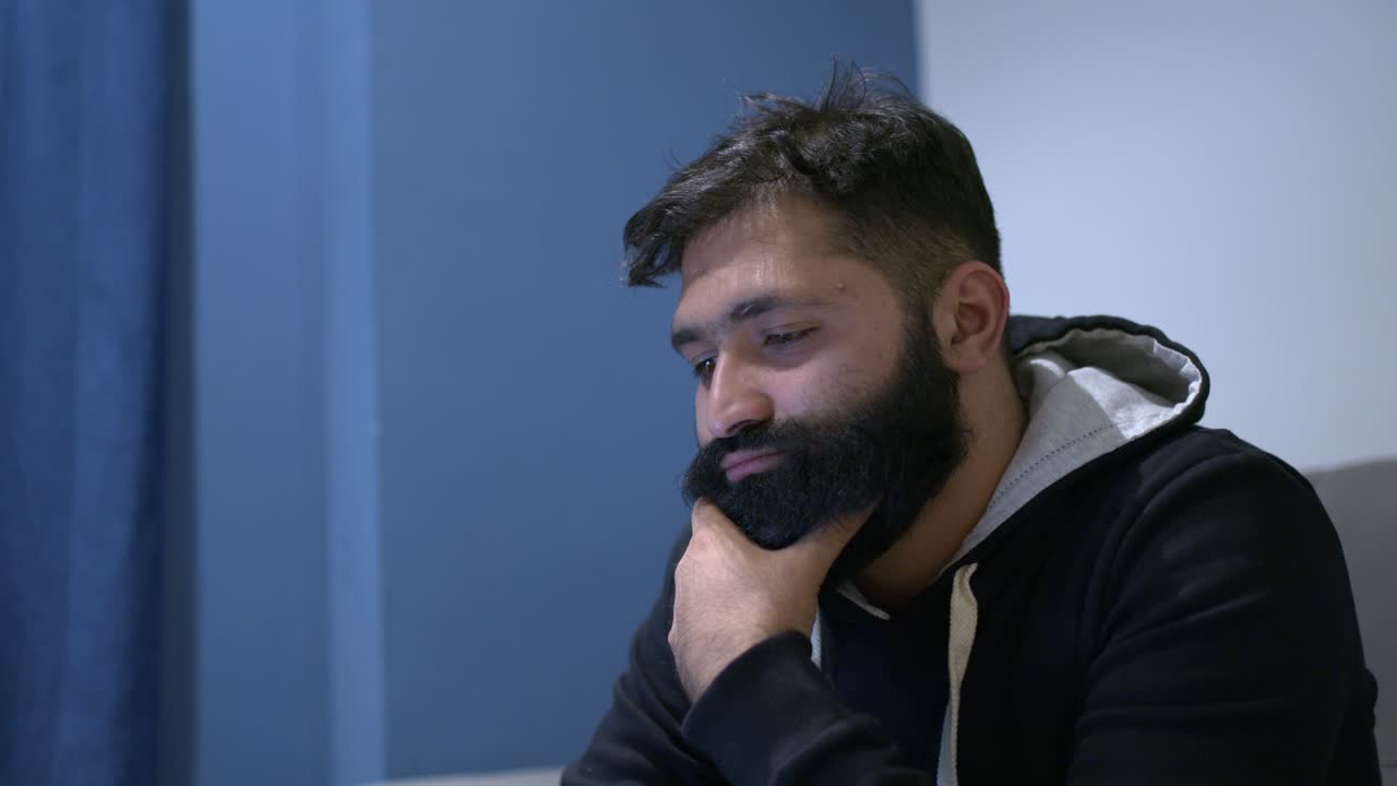 Un hombre aburrido frotándose la barbilla