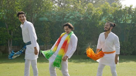 indian men dancing in a park in traditional wear