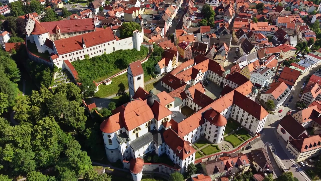 Veduta aerea con drone del castello Hohes Schloss e dell'abbazia bianca di St Mang sopra i tetti del centro storico, Füssen, Germania