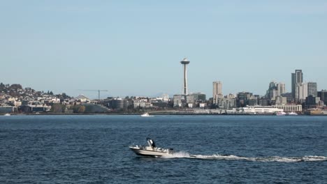 speedboat passing at elliot bay with space needle and seattle center in background in seattle, washington, united states