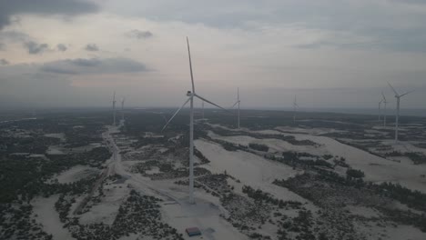 Aariel-shot-of-rows-of-windmills-on-white-sandy-beach-in-Quang-Binh,-Vietnam